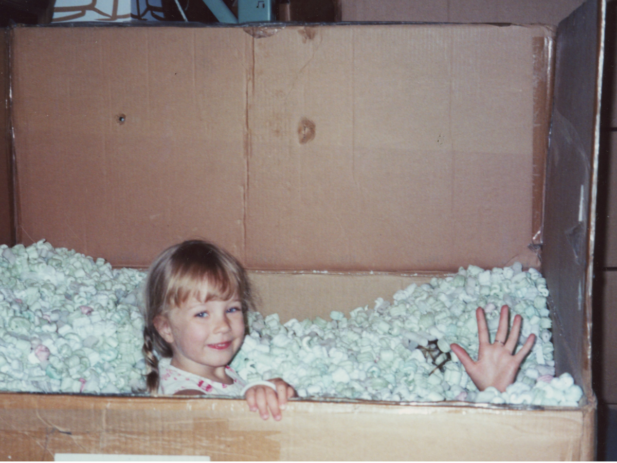 Francesca as a child playing in packing peanuts at the Rosanna warehouse